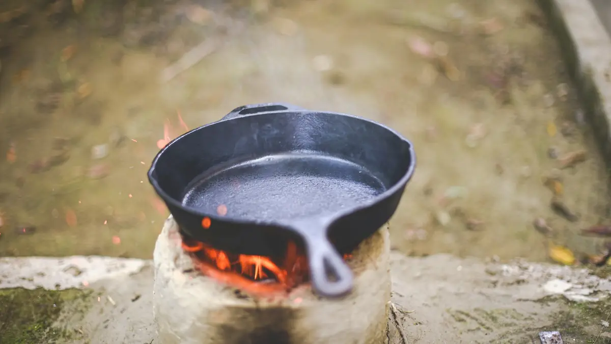 a cast iron skillet sitting on top of a fire pit